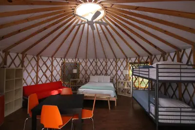 a yurt with a bed and a table and chairs at Yosemite RV Resort in Coarsegold