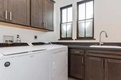 a kitchen with a white dishwasher and wooden cabinets at Creekhouse 1320 in Mammoth Lakes