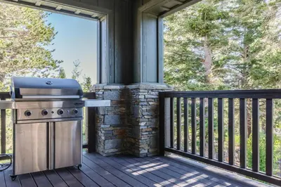 a grill on a screened in porch with a large window at Creekhouse 1320 in Mammoth Lakes