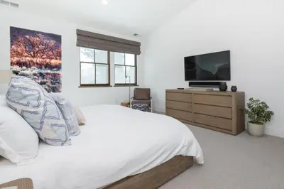 a white bedroom with a bed and a television at Creekhouse 1320 in Mammoth Lakes