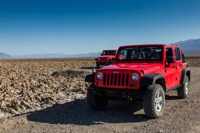 two red jeepneys parked on a dirt road at The Ranch At Death Valley in Death Valley