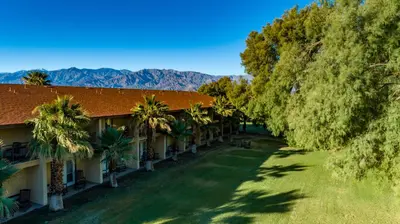a resort with palm trees and mountains in the background at The Ranch At Death Valley in Death Valley