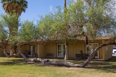 a house with a fallen tree in front of it at The Ranch At Death Valley in Death Valley