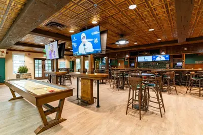 a bar with tables and bar stools and televisions at The Ranch At Death Valley in Death Valley