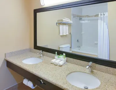 a bathroom with two sinks and a large mirror at Holiday Inn Express Oakdale by IHG in Oakdale