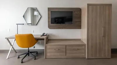 a desk with a yellow chair and a desk with a television at Holiday Inn Express Oakdale by IHG in Oakdale