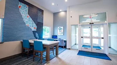 a dining room with a table and blue chairs at Holiday Inn Express Oakdale by IHG in Oakdale