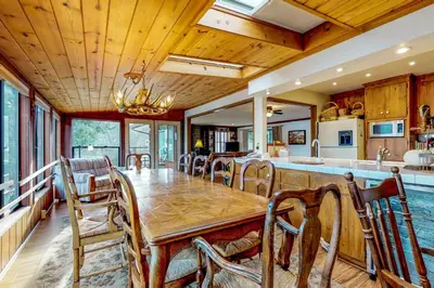 a dining room with a table and a kitchen at Heart's Desire on the Lake (01-275) in Groveland