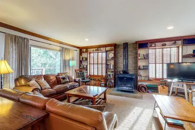 a living room with a leather couch and a fireplace at Heart's Desire on the Lake (01-275) in Groveland