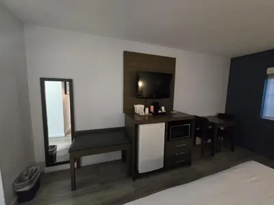 a hotel room with a television and a desk with a chair at Quality Inn & Suites Tulare in Tulare