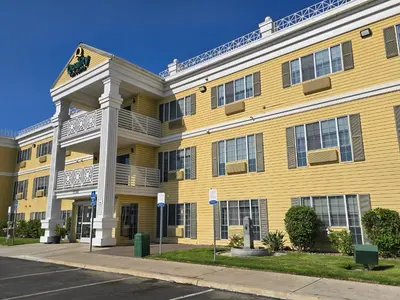 a large yellow building with a clock on it at Quality Inn & Suites Tulare in Tulare