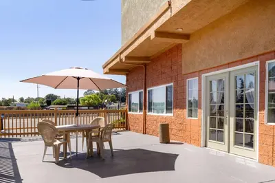 a patio with a table and chairs and an umbrella at Auburn House Hotel in Auburn