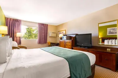 a hotel room with a bed and a flat screen tv at Auburn House Hotel in Auburn