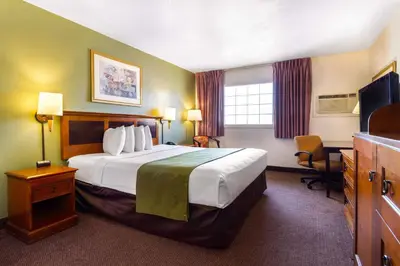 a hotel room with a large bed and a desk at Auburn House Hotel in Auburn