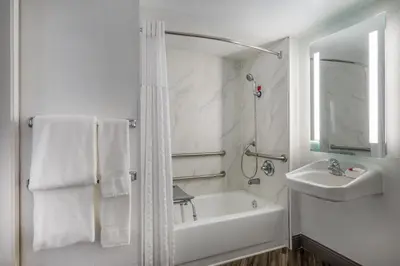 a white bathroom with a sink and a bath tub at La Quinta Inn by Wyndham Sacramento North in Sacramento