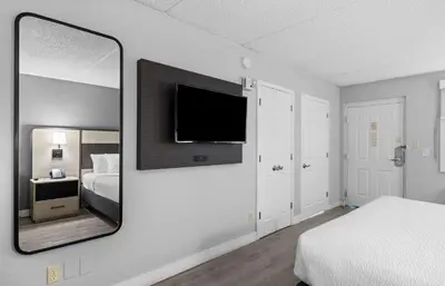 a bedroom with a mirror and a bed and a tv at La Quinta Inn by Wyndham Stockton in Stockton