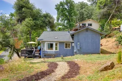 a small blue house in the middle of a field at NEW! Cozy & Secluded House w/Deck - Near Yosemite! in Tuolumne