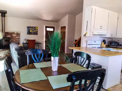 a kitchen and dining room with a table and chairs at NEW! Cozy & Secluded House w/Deck - Near Yosemite! in Tuolumne