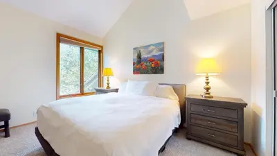 a bedroom with a white bed and a window at Snowcreek 880 Condo in Mammoth Lakes