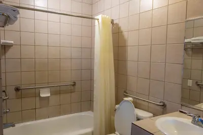 a bathroom with a tub and a toilet and a sink at Kings Rest Motel in Lemoore