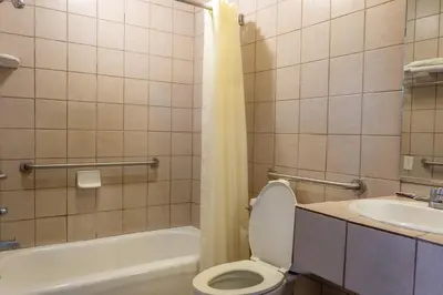 a bathroom with a toilet and a sink at Kings Rest Motel in Lemoore