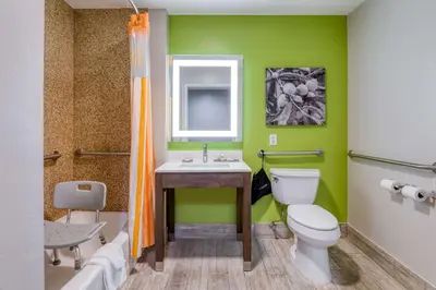 a green bathroom with a toilet and a sink at La Quinta by Wyndham Visalia/Sequoia Gateway in Visalia