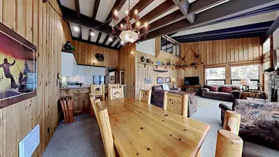 a dining room and living room with a wooden table at Warm and Cozy 4 Bedroom Condo in Mammoth! in Mammoth Lakes