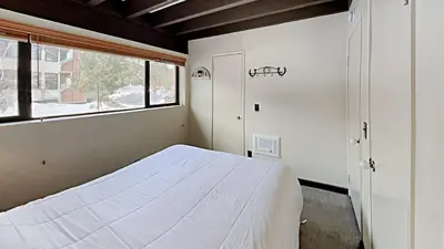 a bedroom with a white bed and a window at Warm and Cozy 4 Bedroom Condo in Mammoth! in Mammoth Lakes