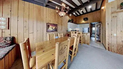 a dining room with wooden walls and a table and chairs at Warm and Cozy 4 Bedroom Condo in Mammoth! in Mammoth Lakes