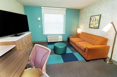 a living room with a couch and a flat screen tv at Home2 Suites By Hilton Roseville Sacramento in Roseville