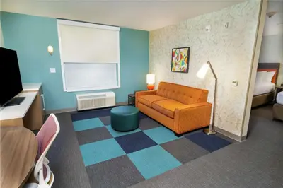 a living room with a couch and a bed at Home2 Suites By Hilton Roseville Sacramento in Roseville