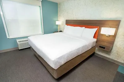 a large bed in a room with a large window at Home2 Suites By Hilton Roseville Sacramento in Roseville