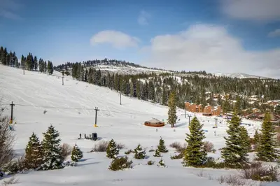 a snow covered slope with a ski resort and trees at Serventi Tahoe Donner Cabin in Truckee