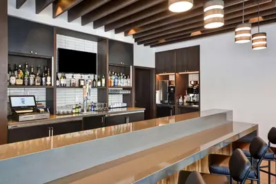 a bar in a hotel with a counter and chairs at Hyatt Place Fresno in Fresno