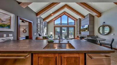a kitchen with a sink and a living room at Luxury 2Br Residence Steps From Heavenly Village & Gondola Condo in South Lake Tahoe