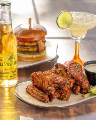 a plate of ribs and a hamburger and a drink at Margaritaville Resort Lake Tahoe in South Lake Tahoe