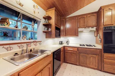 a kitchen with wooden cabinets and a sink at Escape to Yosemite in Groveland