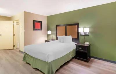 a bedroom with a large bed and green walls at Extended Stay America Suites - Fresno - North in Fresno