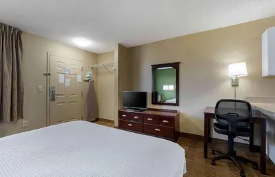 a hotel room with a bed and a desk and a mirror at Extended Stay America Suites - Sacramento - White Rock Rd in Rancho Cordova