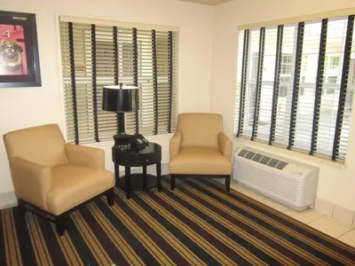two chairs and a lamp in a room with windows at Extended Stay America Suites - Sacramento - White Rock Rd in Rancho Cordova