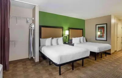 two beds in a room with green walls at Extended Stay America Suites - Sacramento - Arden Way in Sacramento