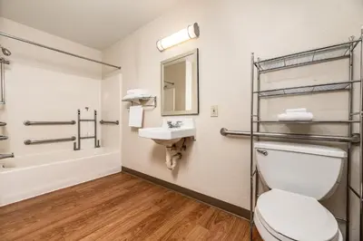 a bathroom with a toilet and a sink and a tub at HomeTowne Studios by Red Roof Fresno - West in Fresno
