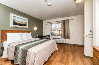 a hotel room with a bed and a window at HomeTowne Studios by Red Roof Fresno - West in Fresno