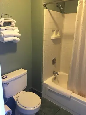 a bathroom with a toilet and a shower and a tub at Applegate Inn in Atwater