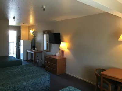 a hotel room with two beds and a television and a table at Applegate Inn in Atwater