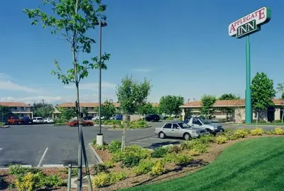 a parking lot with cars parked in front of a store at Applegate Inn in Atwater