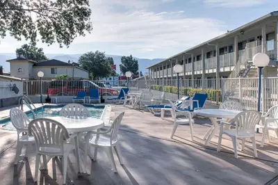a group of tables and chairs in front of a building at Motel 6-Bishop, CA in Bishop