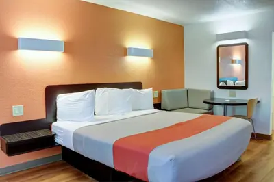 a hotel room with a large bed and a table at Motel 6-Bishop, CA in Bishop