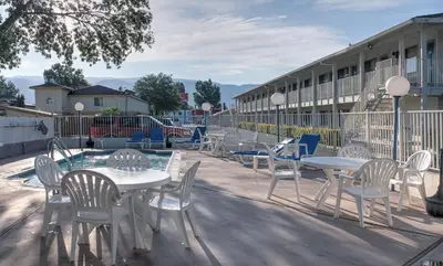 a group of tables and chairs in front of a building at Motel 6-Bishop, CA in Bishop