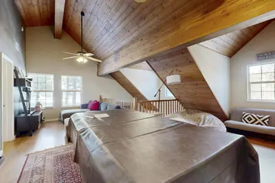 a large living room with a large bed and wooden ceilings at Welcoming Tahoe-Donner Cabin in Truckee